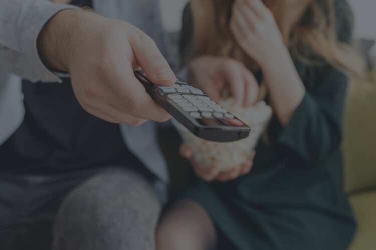 close up of man's hand holding tv remote